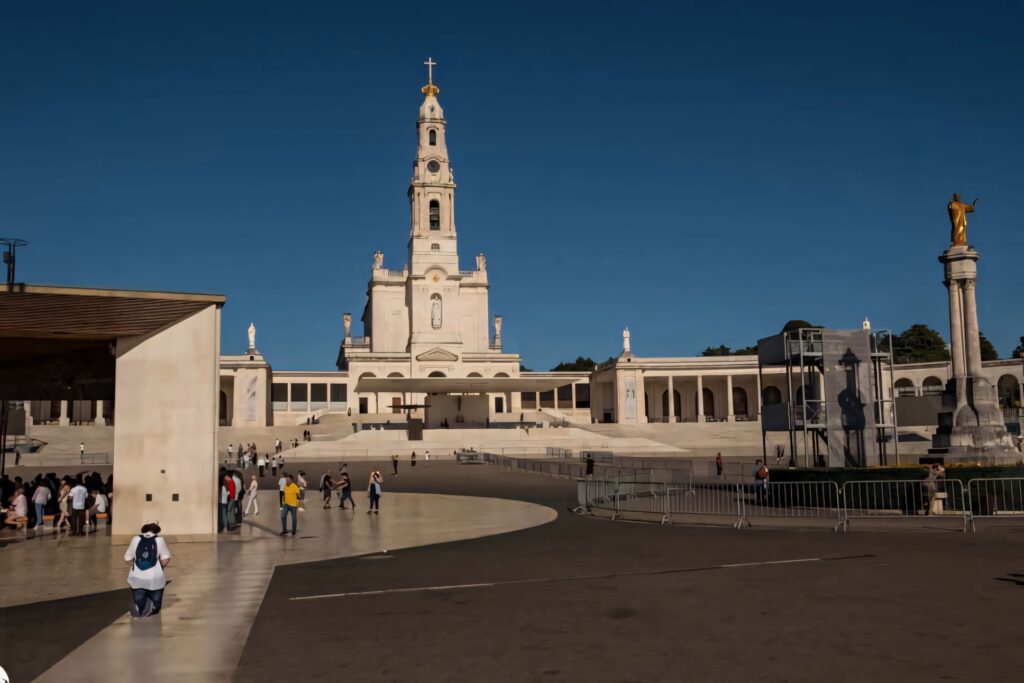 Serene Fatima Sanctuary Wallpaper: Man Praying by Illuminated Basilica