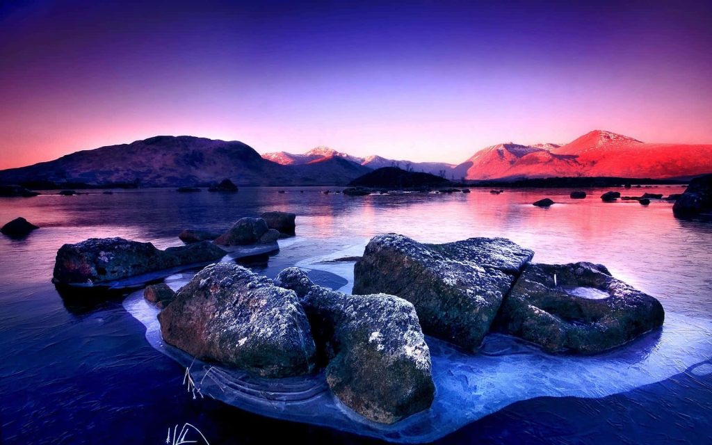 Frozen lake with frost rocks and pink twilight sky mountains peaceful winter wallpaper