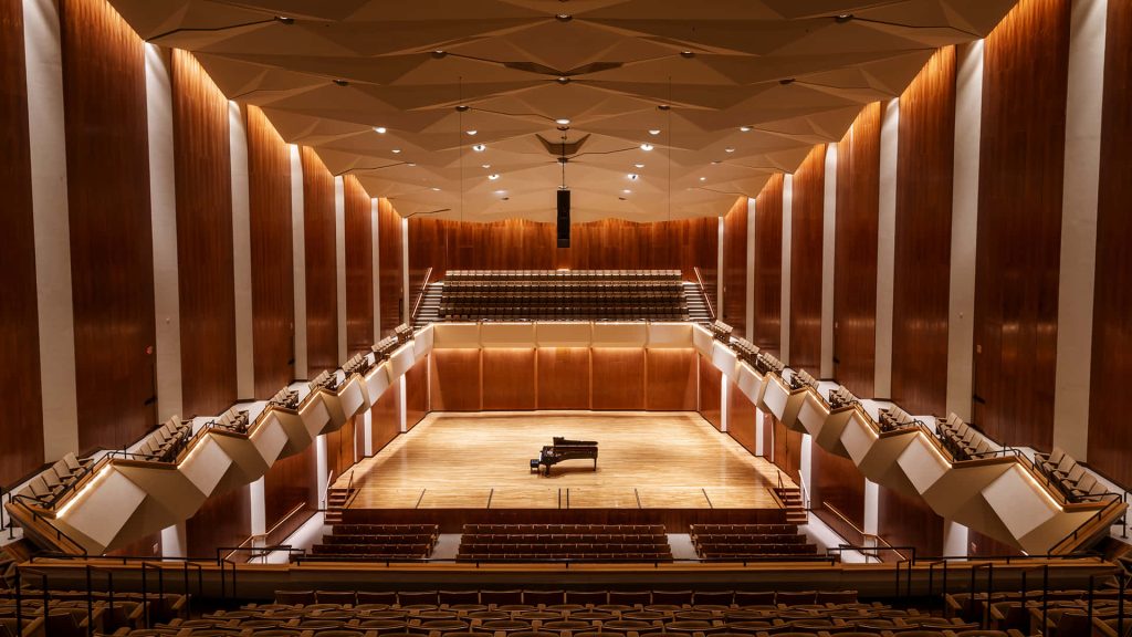 Gallagher Bluedorn Performing Arts Center stage with grand piano warm lighting wood paneling background Wallpaper