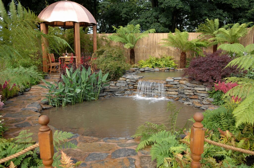 Serene garden wallpaper with cascading waterfall lush greenery rustic arbor and stone pathways