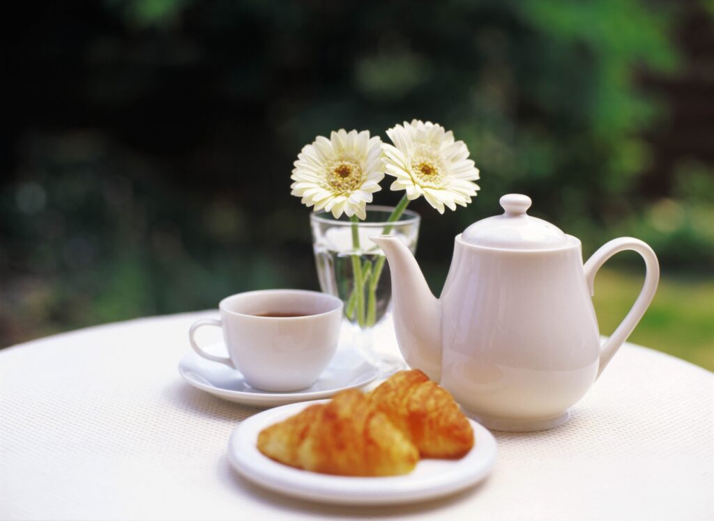 Serene Garden Wallpaper: Teapot, Tea, Croissants & Fresh Flowers
