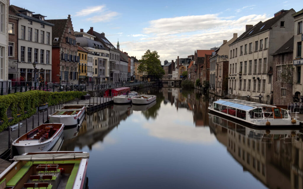 Serene Ghent Canal View: Charming Buildings & Boats Wallpaper Background