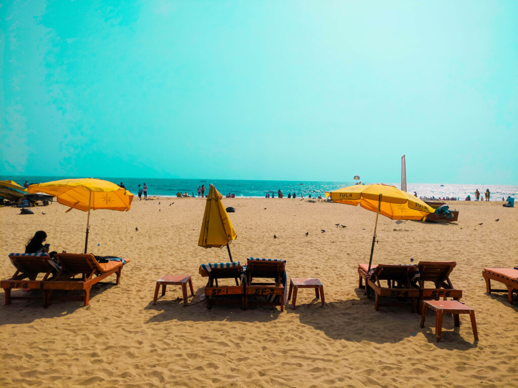 Goa Beach Wallpaper: Serene Scene with Yellow Umbrellas & Turquoise Sea