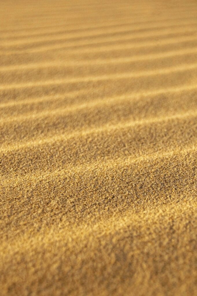 Serene Golden Sand Wallpaper: Gentle Wave Patterns & Soft Blur Effect