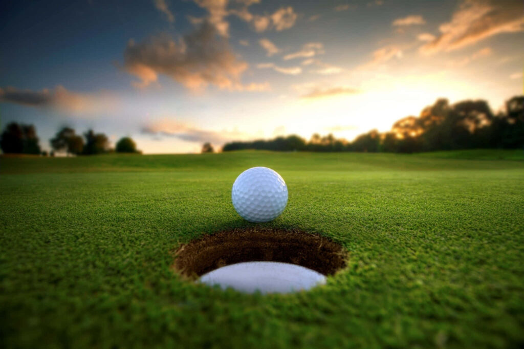 Tranquil Golf Course Wallpaper: Golf Ball at Sunset – Lush Background