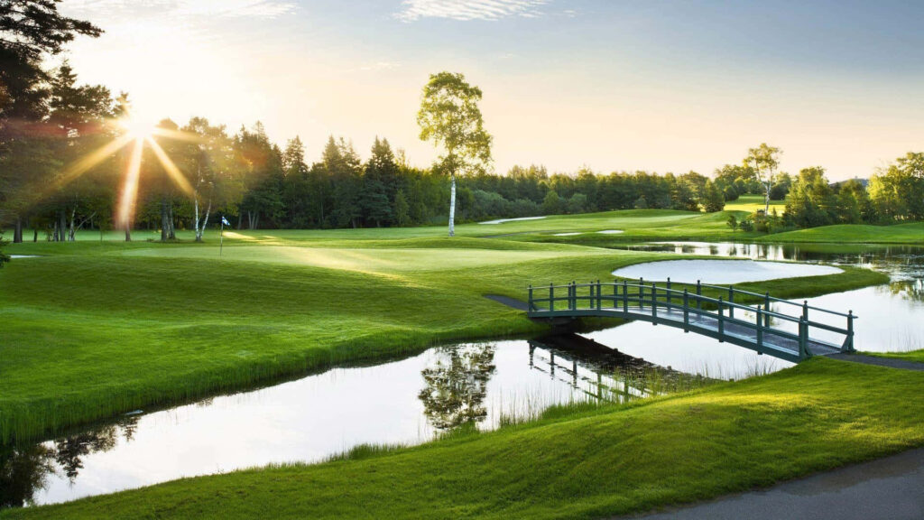 Tranquil Golf Course Wallpaper with Wooden Bridge and Sunlit Greens