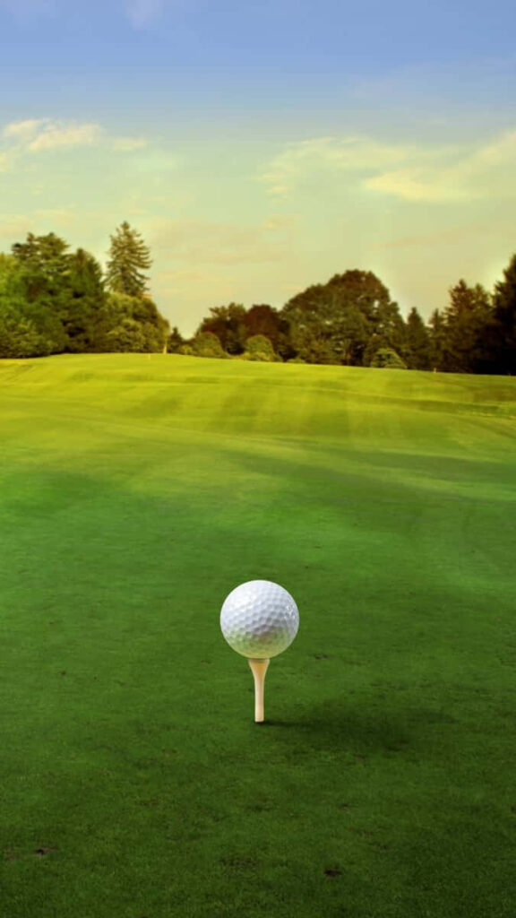 Serene Golf Course Scene: Ball on Tee Amidst Lush Green Grass Wallpaper