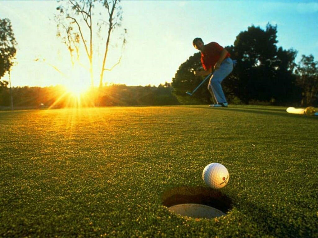 Sunset Golf Shot Wallpaper: Serene Scene of a Golfer at the Hole