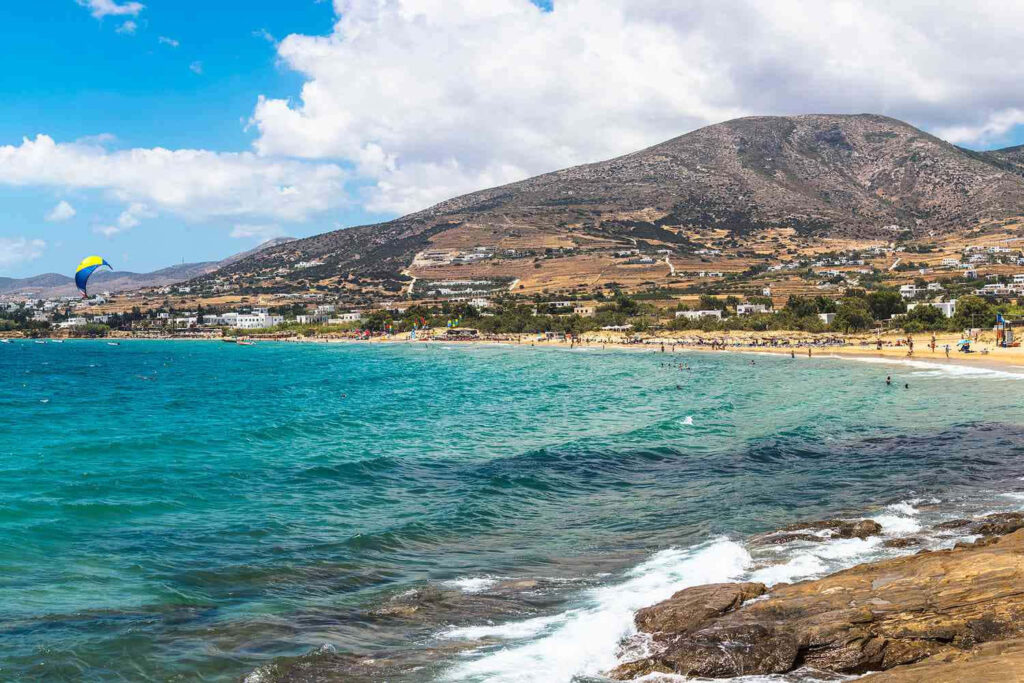 Serene Greek Beach at Sunset: Turquoise Waters & Mountain Backdrop Wallpaper