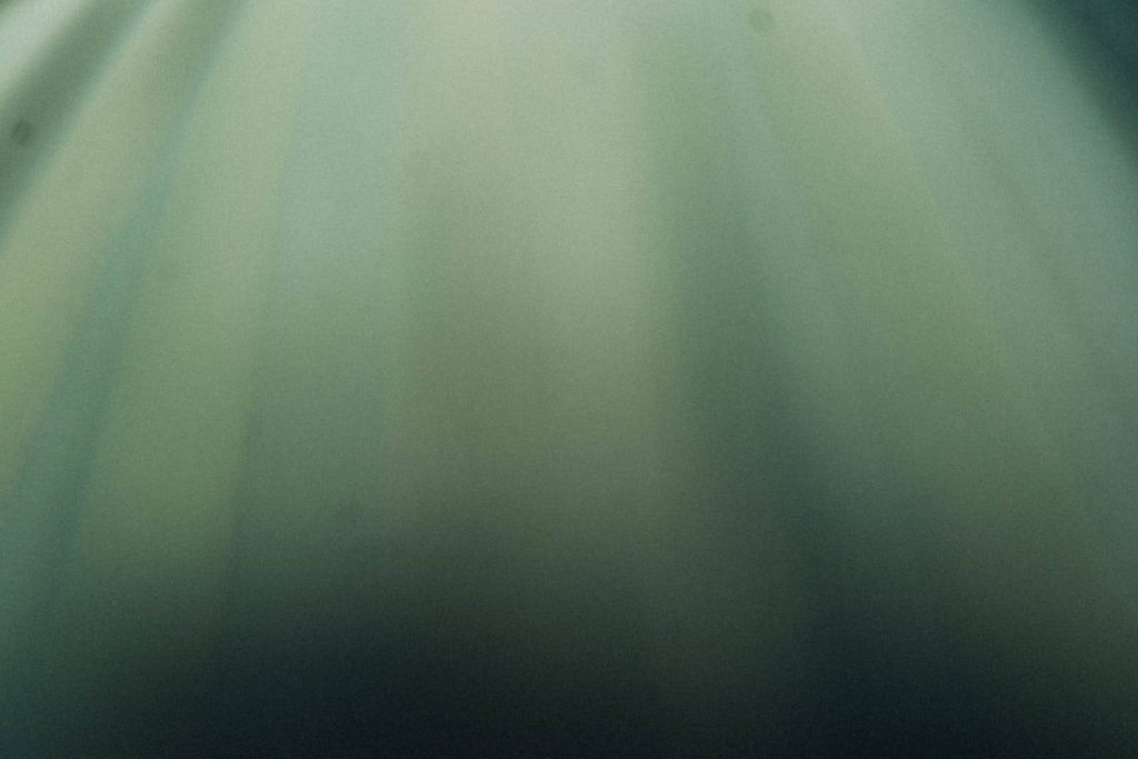 Minimalist smooth green gradient wallpaper with soft underwater tones for calm desktop background
