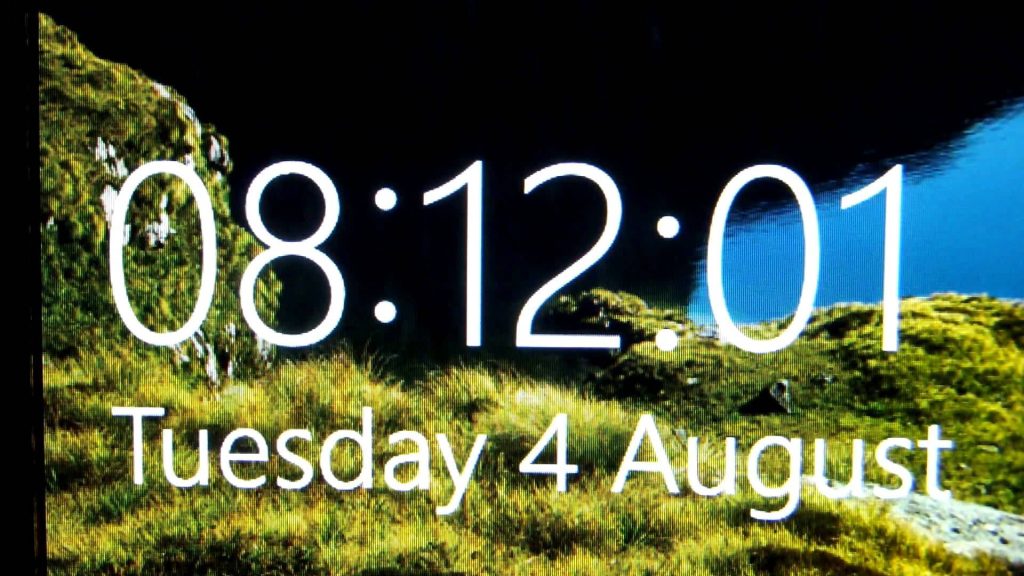 Windows lock screen with green hillside landscape blue sky and white digital clock 08:12 Tuesday 4 August Wallpaper