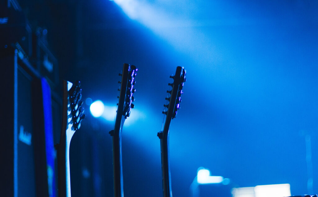 Serene Guitar Heads Wallpaper: Electrifying Blue Lighting Background