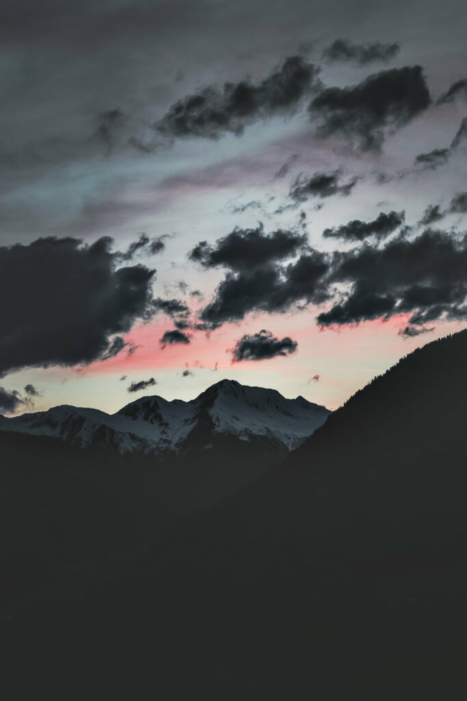 Serene Mountain Peak HD Wallpaper: Dramatic Clouds & Soft Hues
