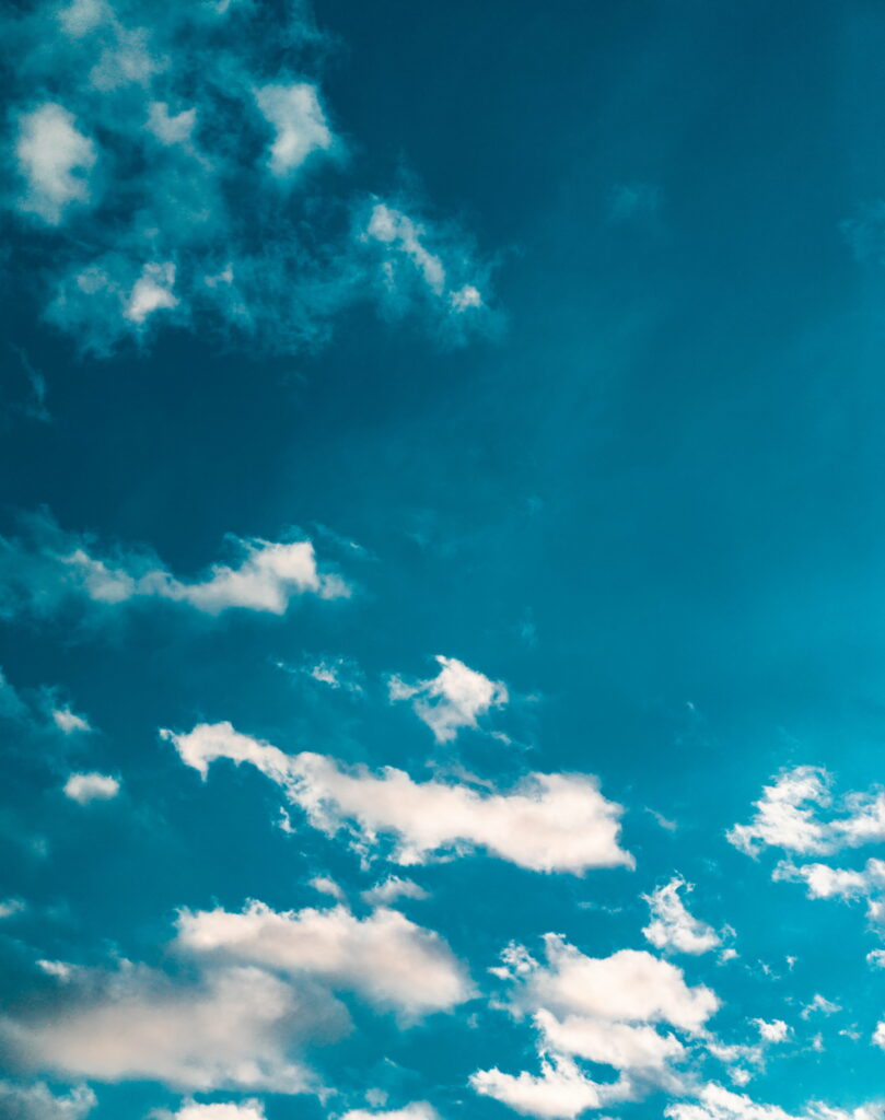 Serene HD Phone Wallpaper: Fluffy Clouds & Deep Blue Sky Background