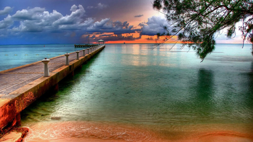 Tranquil Harbor Sunset: Serene Pier & Lush Greenery Reflection Wallpaper
