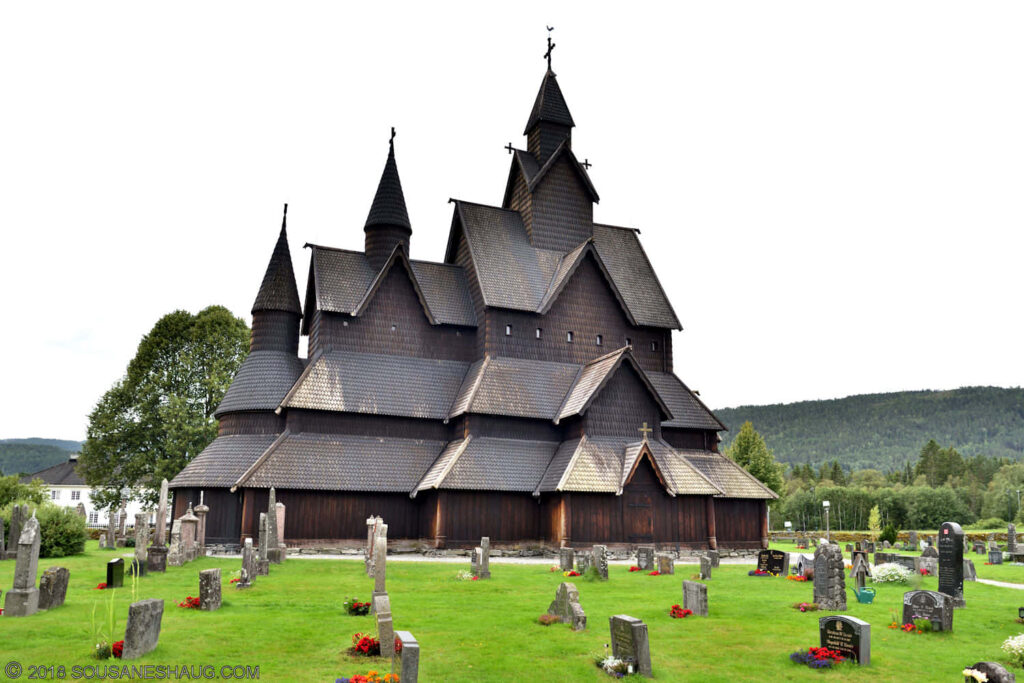 Serene Heddal Stave Church Wallpaper with Vibrant Rose Graveyard