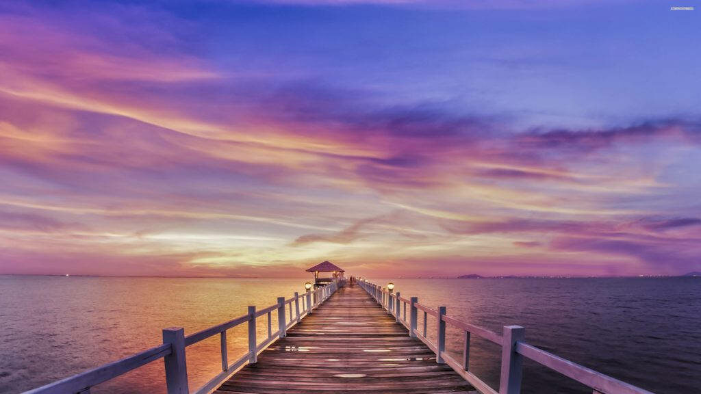 Picturesque Pier Tranquility: A Mesmerizing Sunrise Nature Backdrop Ablaze in Vivid Hues of Blue, Purple, Pink, and Orange Wallpaper