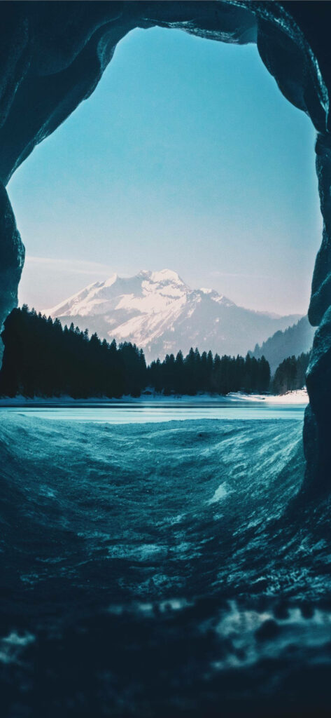 Serene Lake & Forest View from Cave with Snow-Capped Mountain Wallpaper