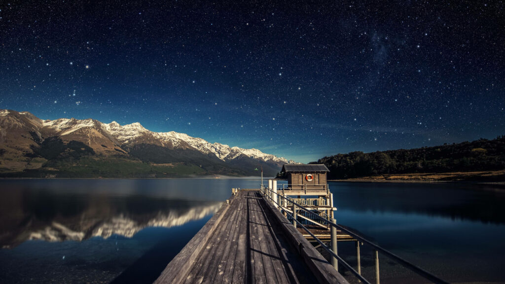 Tranquil Lake View Wallpaper: Starry Night & Cozy Cabin Scene