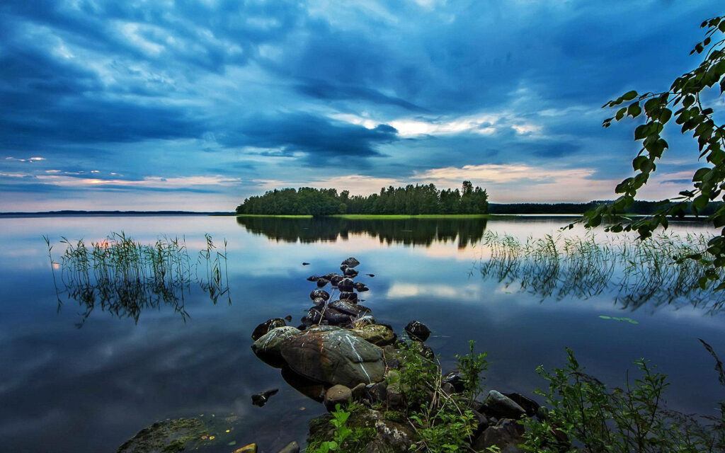 Serene Lakefront Wallpaper: Rocky Shores & Lush Greenery Scene