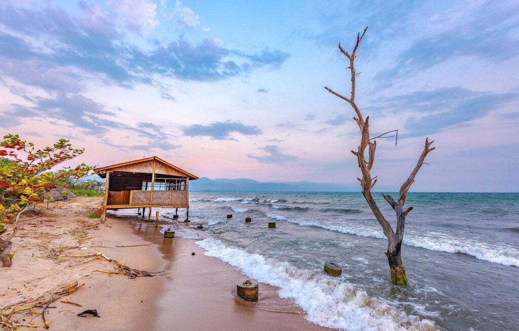 Tranquil Lakeside Wallpaper: Rustic Hut & Peaceful Shore Scene