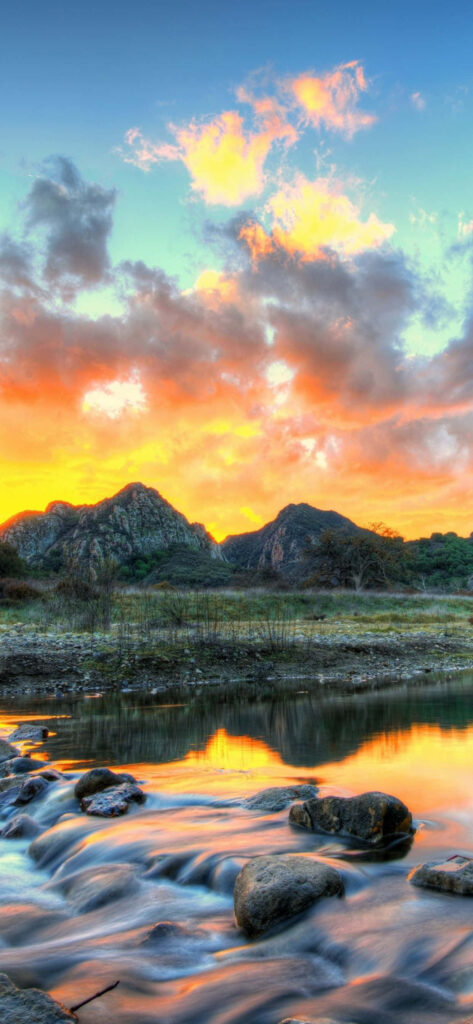 Serene Landscape: Reflective River and Rugged Mountains at Sunset Wallpaper
