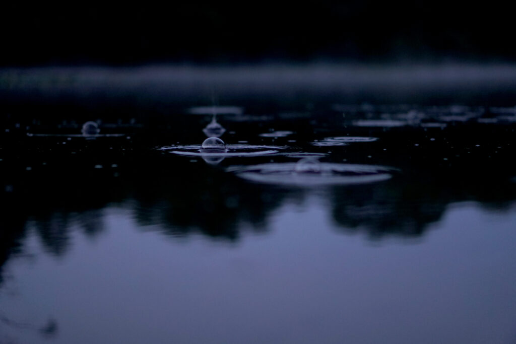 Serene Macro Wallpaper: Bubbles Creating Ripples on Dark Water