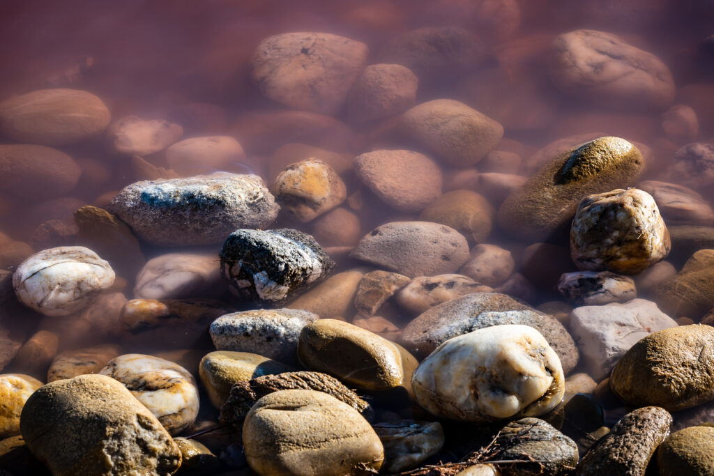 Serene Macro Shot of Stones & Pebbles in Calm Water - Wallpaper Background