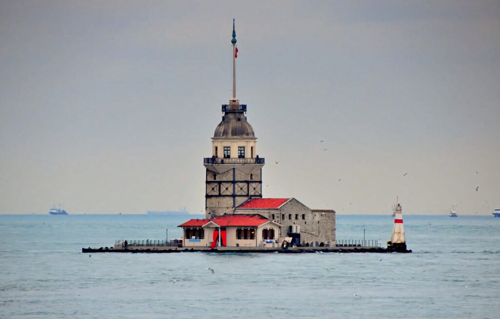 Serene Maiden Tower Wallpaper: Calm Waters & Clear Sky Background