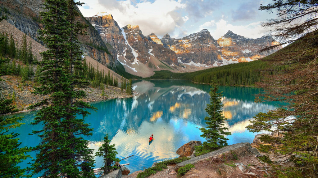 A Captivating View of Nature's Magnificent Blue Lake & Towering Mountains Wallpaper