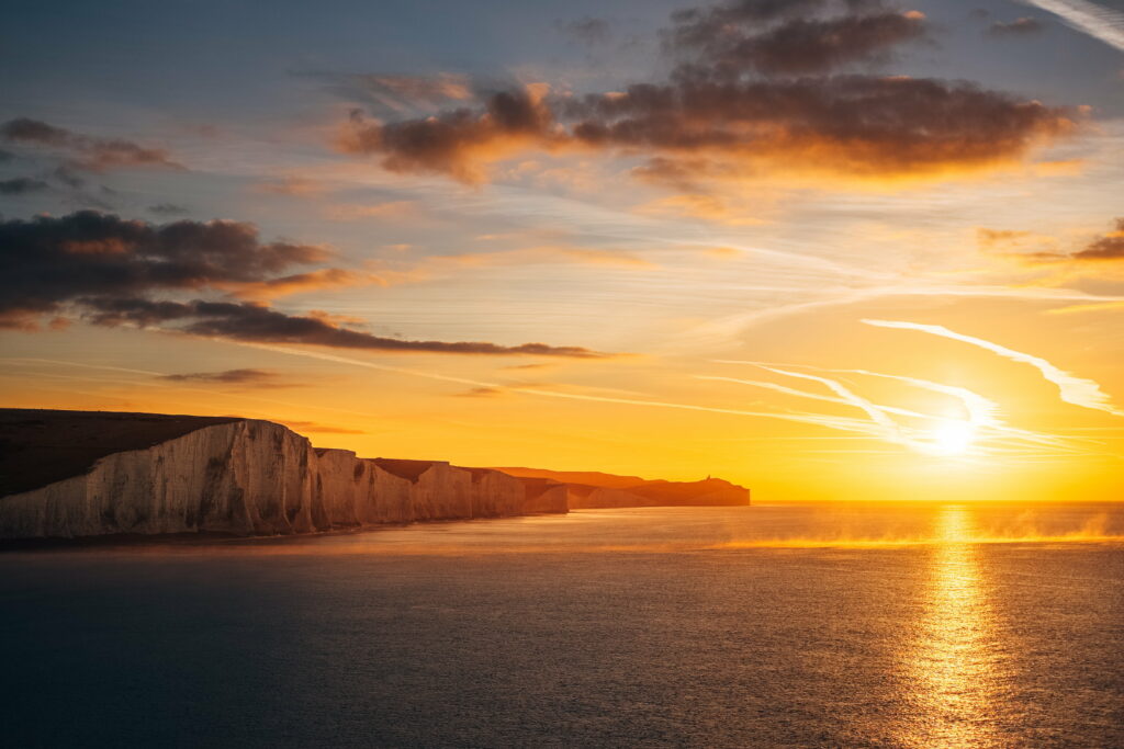 Majestic Sky Painting: Captivating Ocean Sunset by the Seven Sisters Cliffs Wallpaper