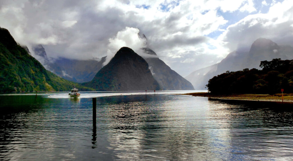 Serene Milford Sound: Cloud-Capped Mountains & Reflective Waters Wallpaper