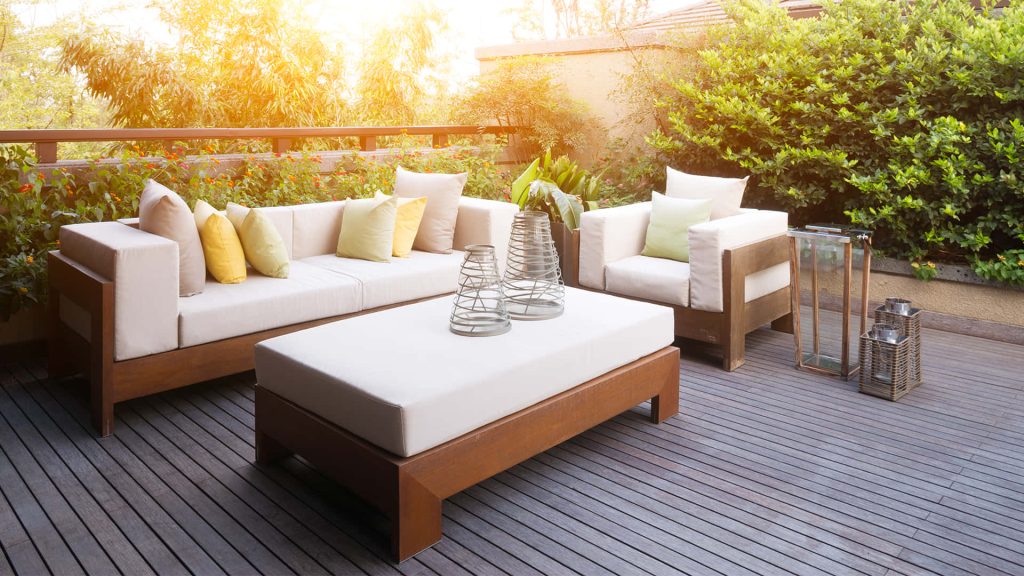 Modern balcony virtual background with outdoor furniture lush greenery and warm sunlight Wallpaper