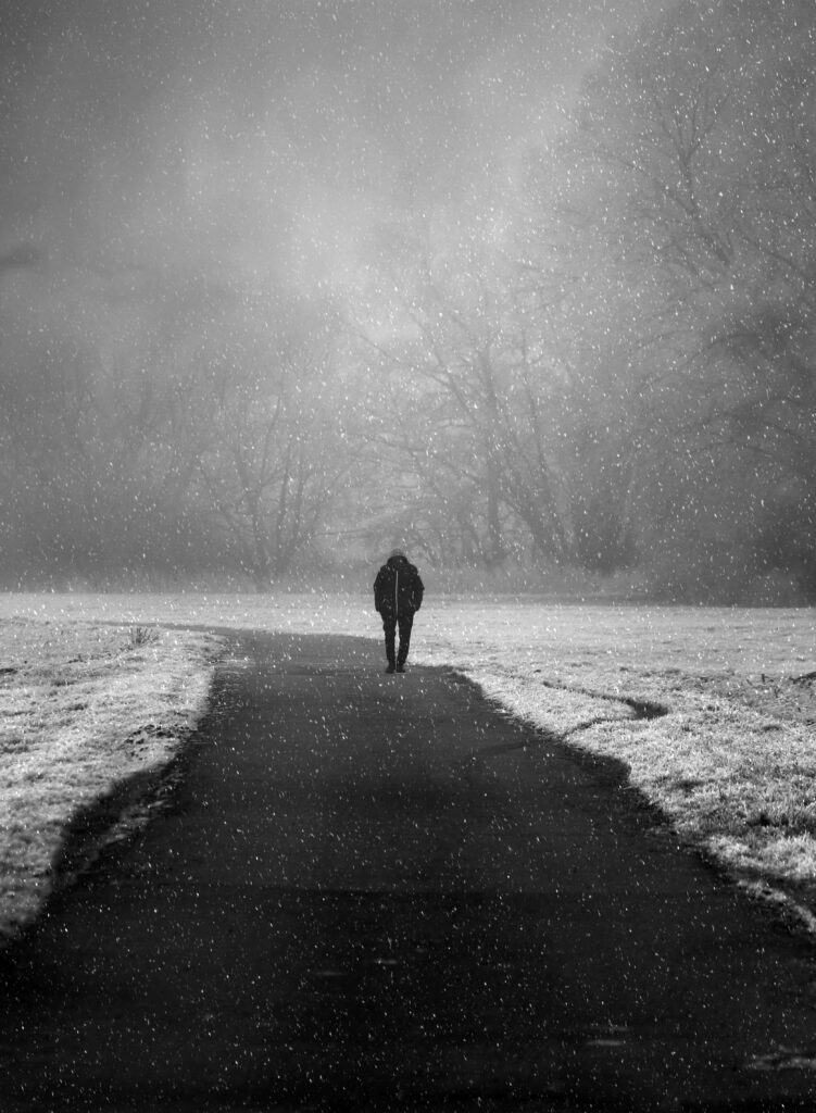 Serene Monochrome Wallpaper: Lone Figure in Gentle Snowfall