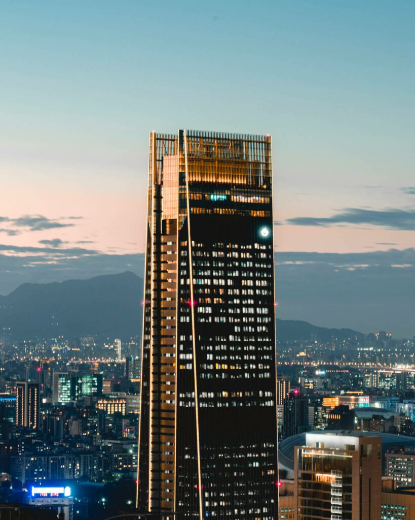 Serene Morning Skyscraper Wallpaper with Vibrant Cityscape & Mountains