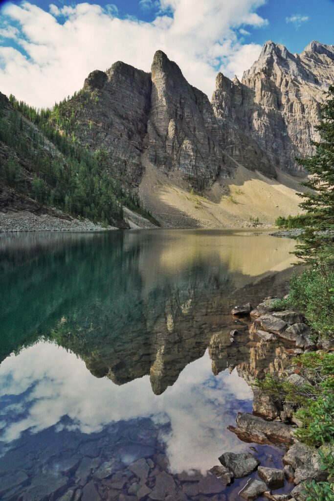 Crystal-clear lake reflecting rocky mountain peaks and vibrant blue sky in serene nature wallpaper