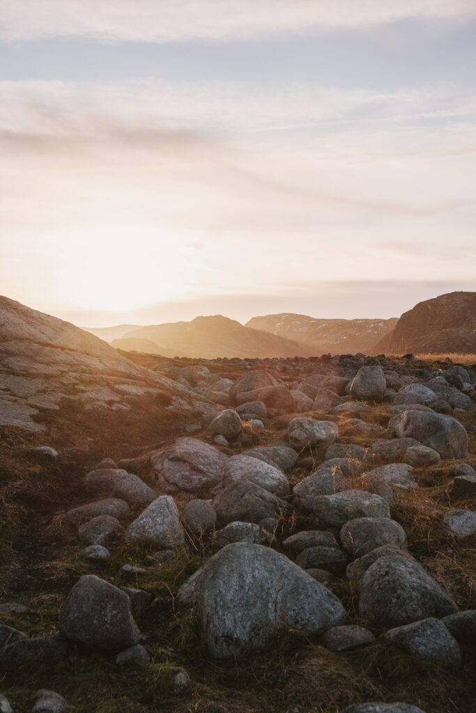 Serene mountain landscape wallpaper with warm light earthy tones and textured rocky foreground
