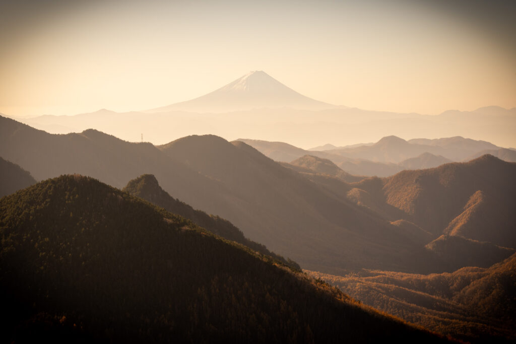 Serene mountain landscape with misty peaks golden light rolling hills peaceful nature wallpaper