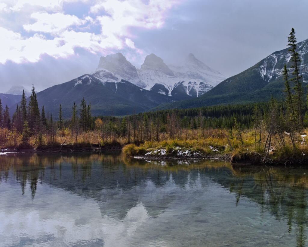 Mountain landscape wallpaper with snow-capped peaks rocky outcrops and reflective serene lake