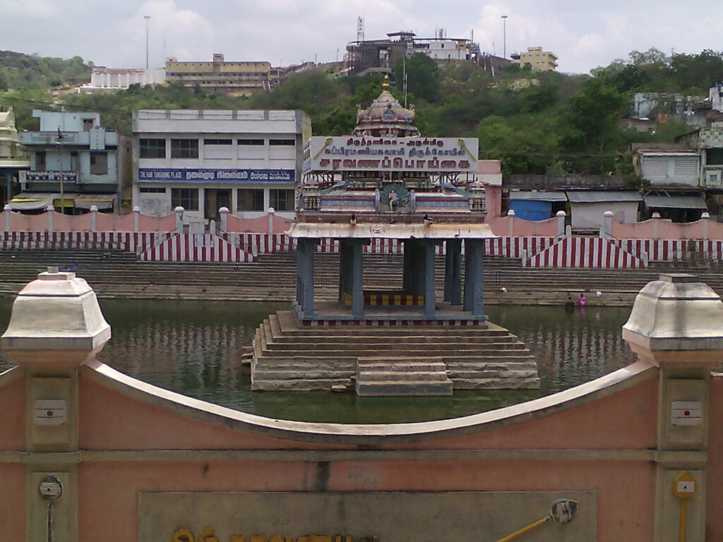 Serene Murugan Temple by Calm Lake - Vibrant Wallpaper Background