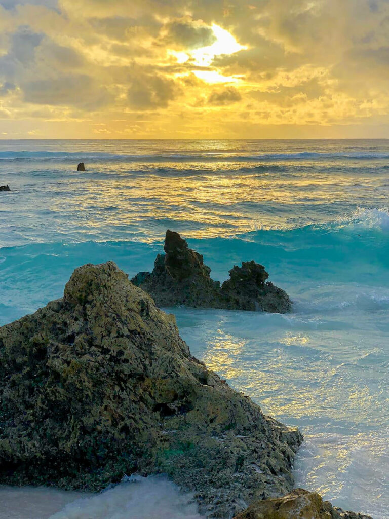 Serene Nauru Waves Wallpaper: Golden Sunset over Coastal Rocks