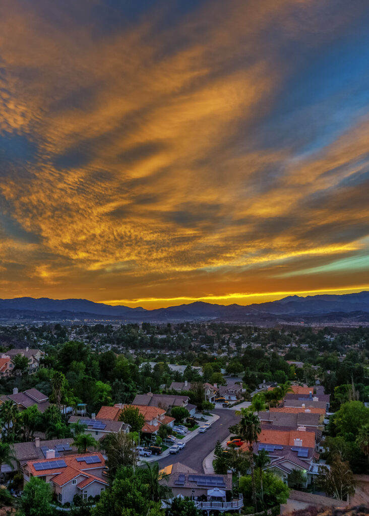 Serene Sunset Neighborhood Wallpaper with Red-Tiled Roofs & Mountains