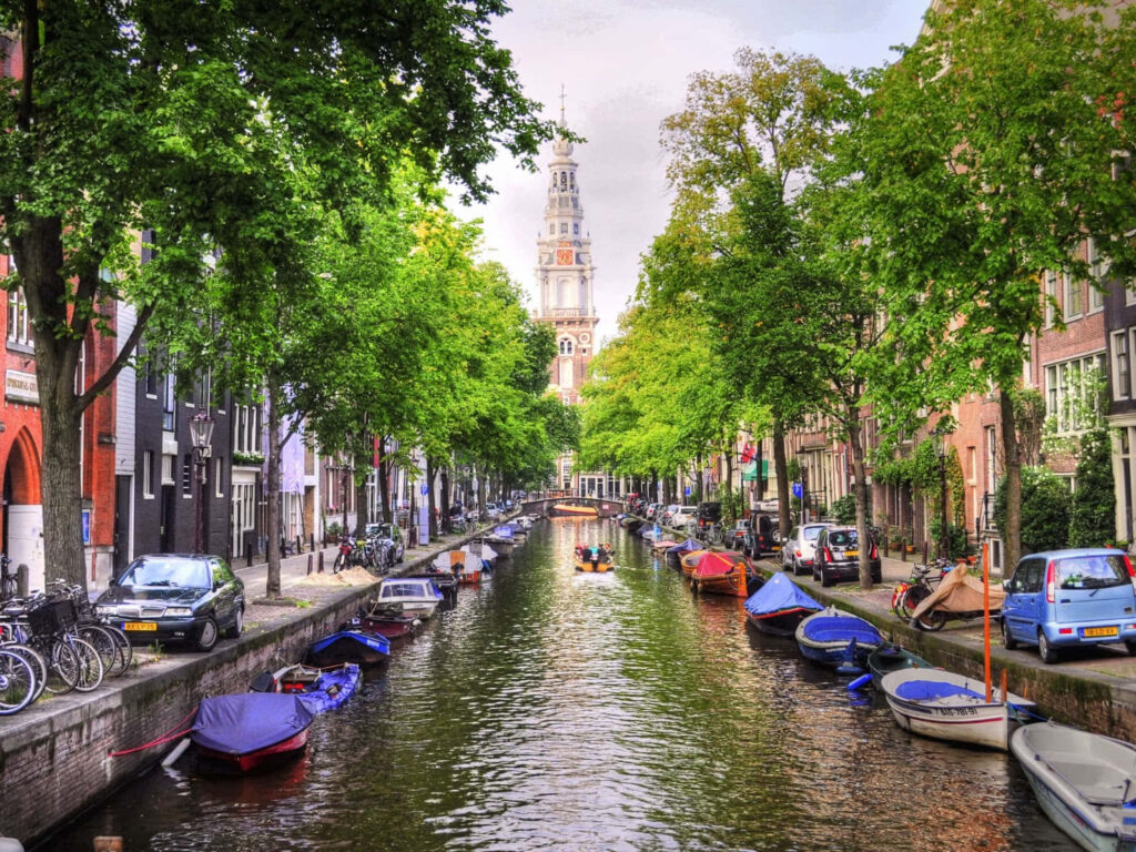 Serene Netherlands Canal: Lush Trees, Charming Buildings & Tower Wallpaper