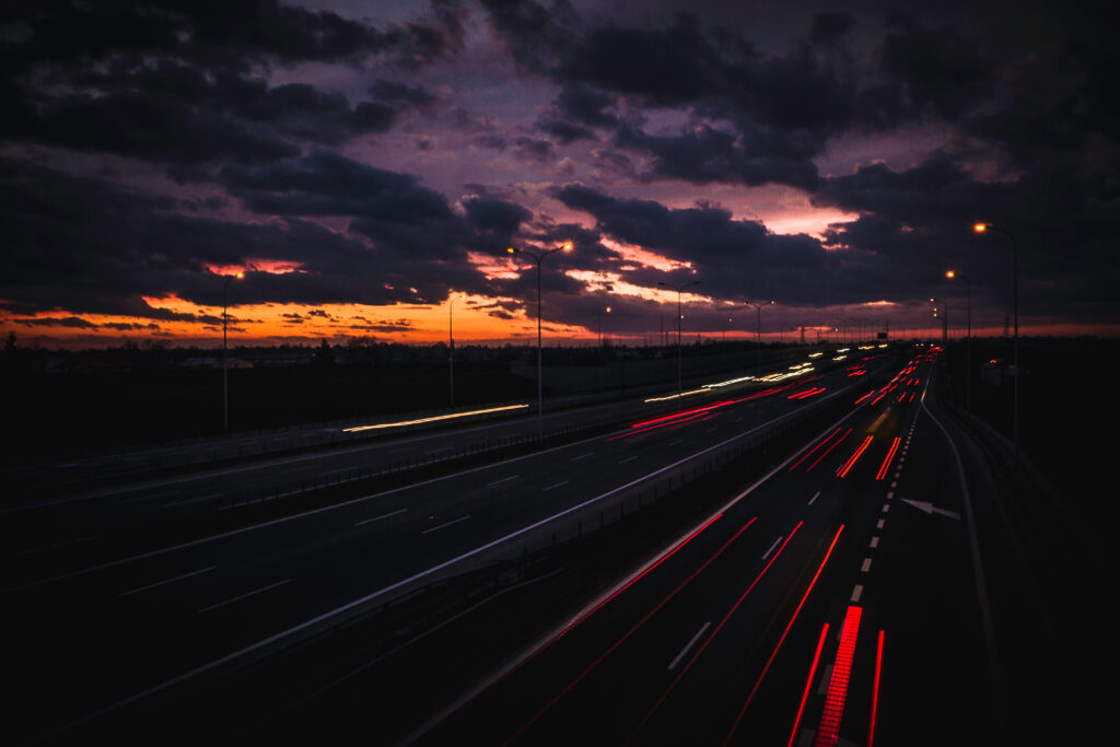 Serene Night Cityscape Wallpaper: Empty Road & Dramatic Skies