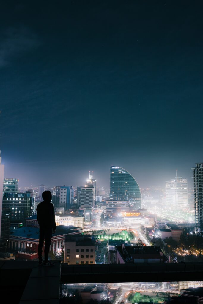 Serene Night Cityscape Wallpaper: Solitude on a Rooftop