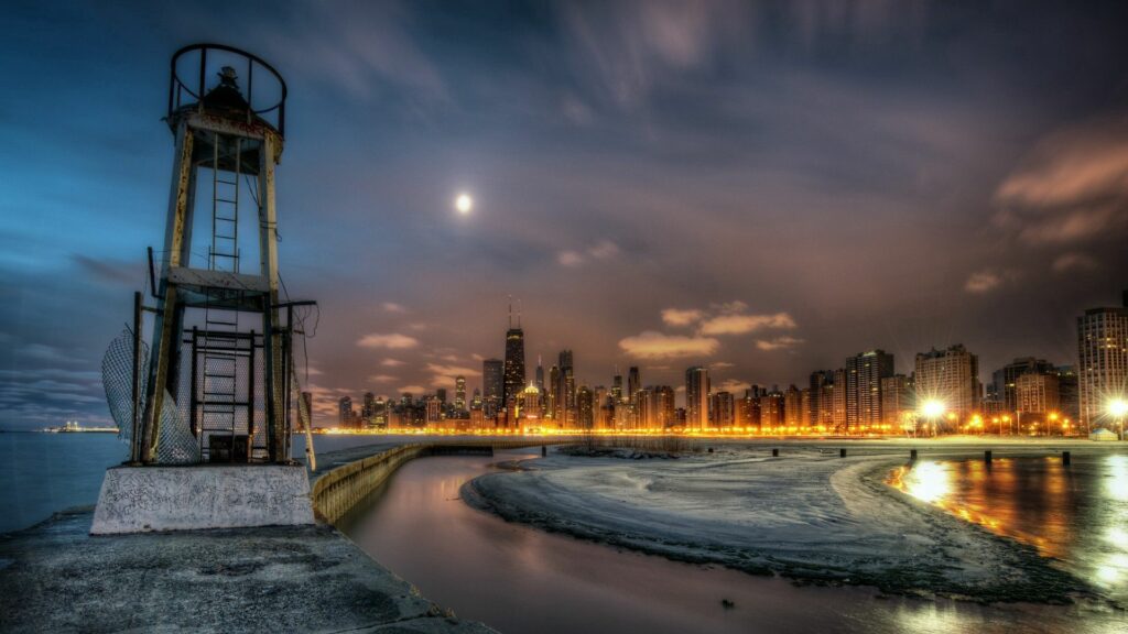 Serene Night Lighthouse Wallpaper with City Skyline & River Reflections