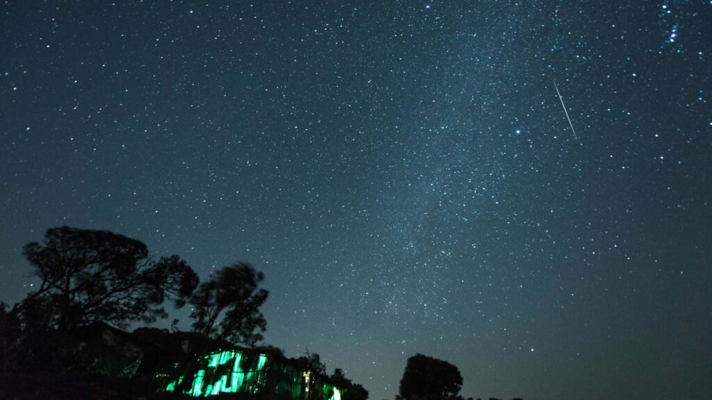 Tranquil Night Sky Wallpaper: Shooting Star Over Serene Landscape