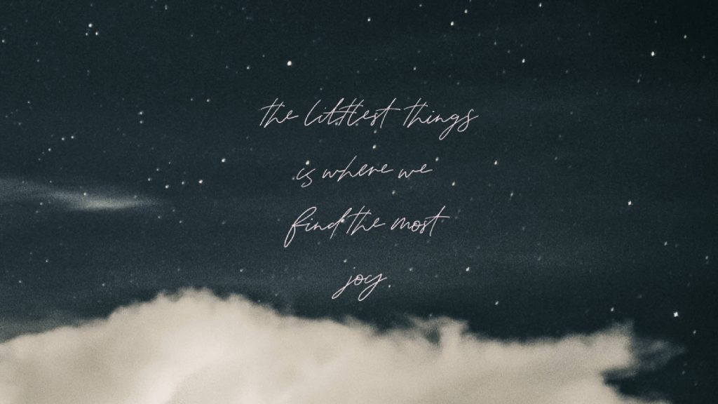 Serene dark night sky wallpaper with twinkling stars and cursive inspirational quote centered