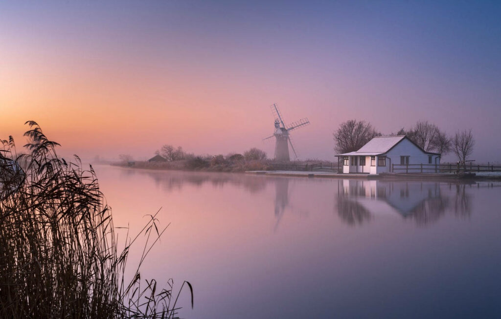 Serene Norfolk Broads Sunrise Wallpaper: Cottage & Windmill Reflection