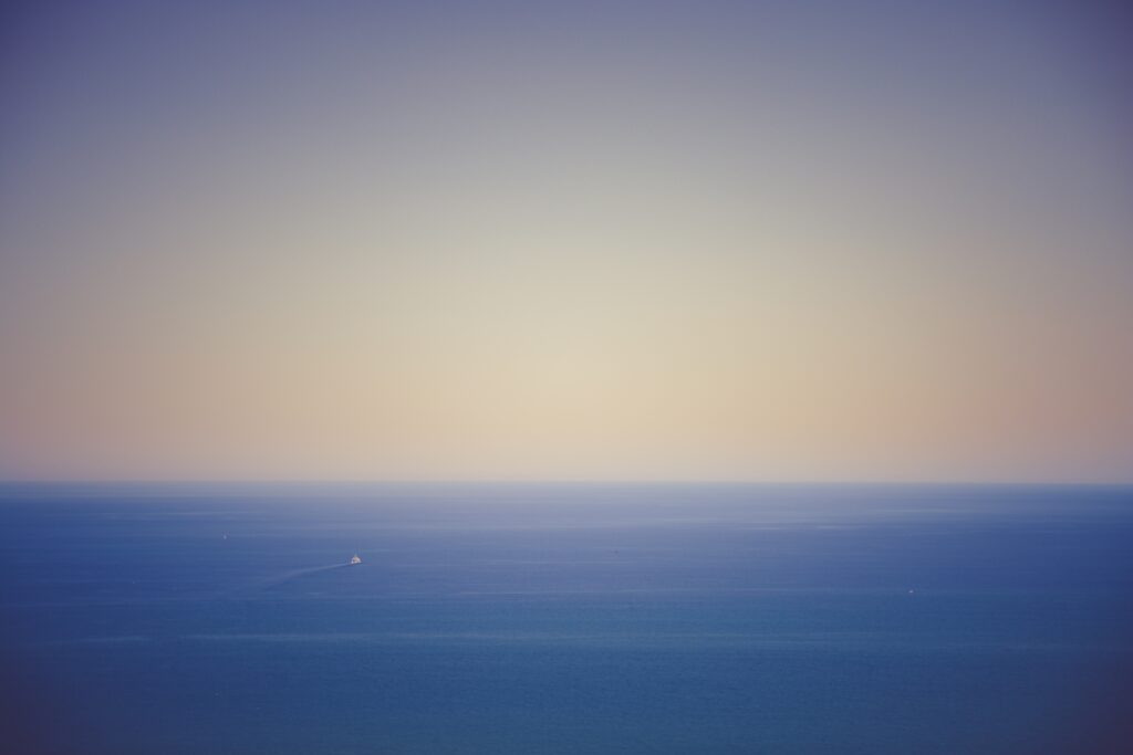 Calming ocean wallpaper with soft blue tones and pastel gradient sky for peaceful desktop background